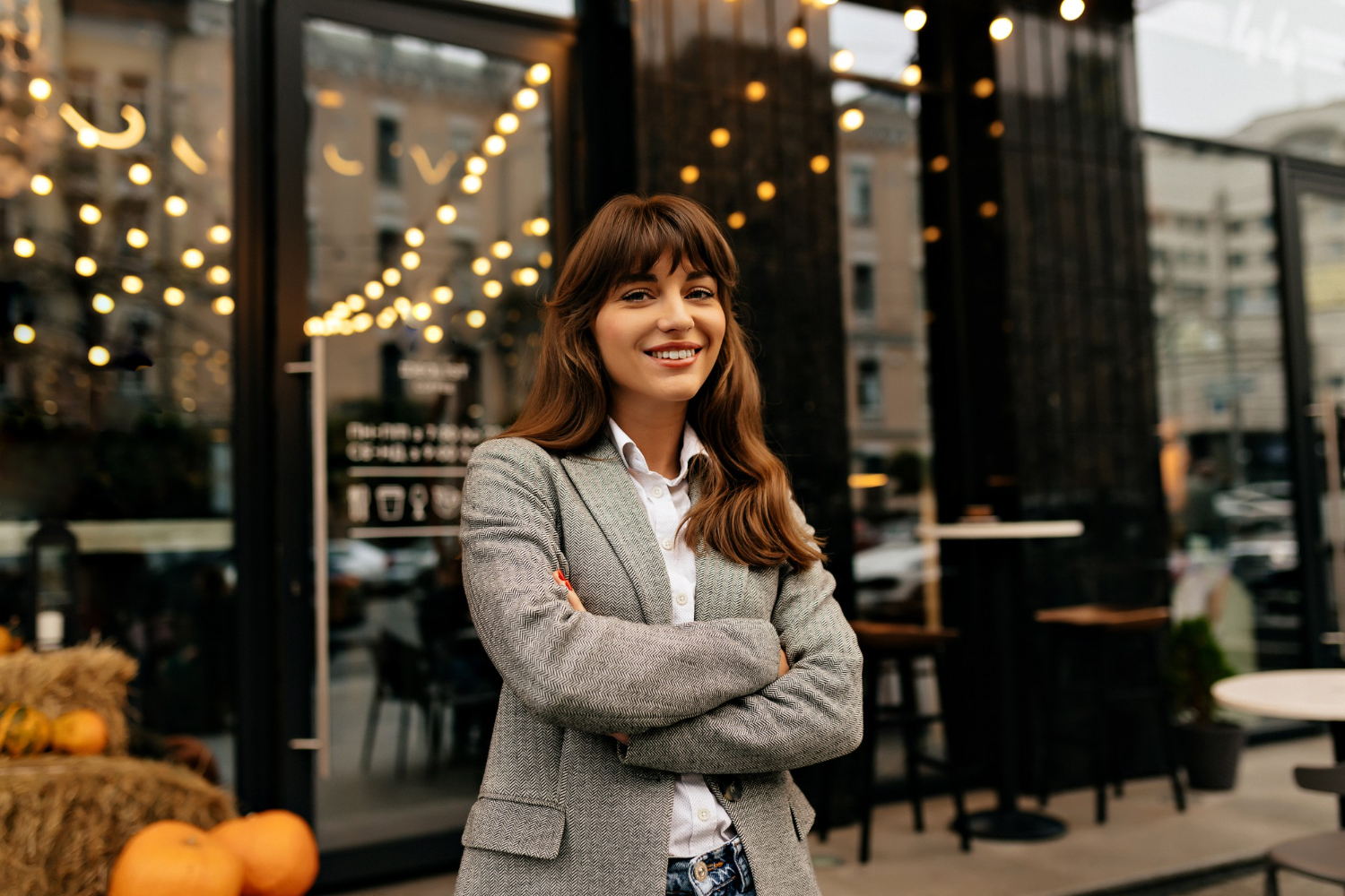 Mujer emprendedora en un restaurante, sonríe por su éxito empresarial.