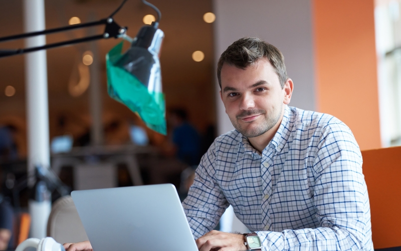 Emprendedor reflexivo frente a laptop analizando errores y mitos al iniciar un proyecto de emprendimiento de alto impacto